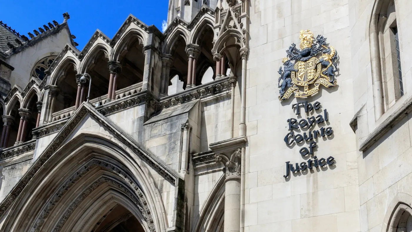 Historic court building exterior with justice emblem representing legal case involving wealthy student and $2 billion financial fraud links